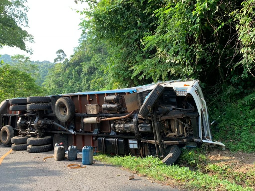 Kondisi truk bermuatan air minum dalam kemasan terbalik.