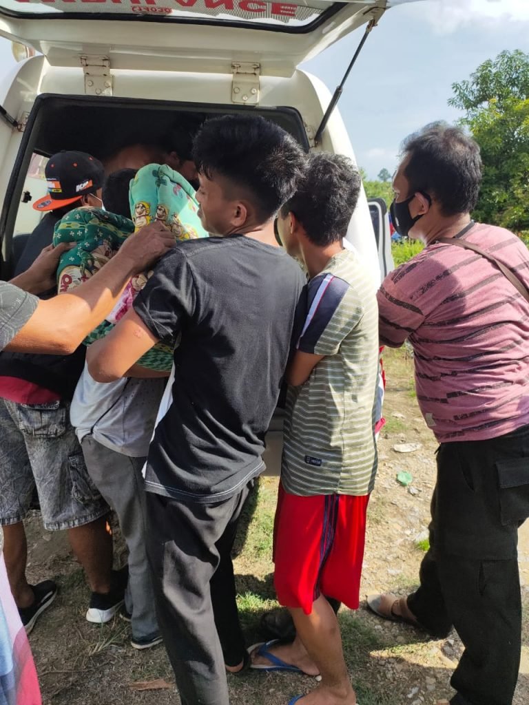 Warga Desa Matalino berusaha mengevakuasi jenazah di dalam ambulans yang kecelakaan.