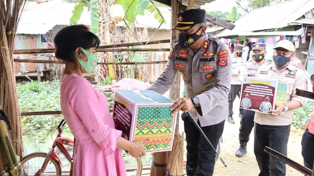 Kapolres Kendari, AKBP Didik Erfianto saat membagikan bantuan sosial di Kampung Pemulung, Kelurahan Bende, Kecamatan Kadia, Kota Kendari. 