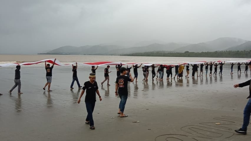 Pengibaran Bendera Merah Putih di Pantai Batu Gong. 