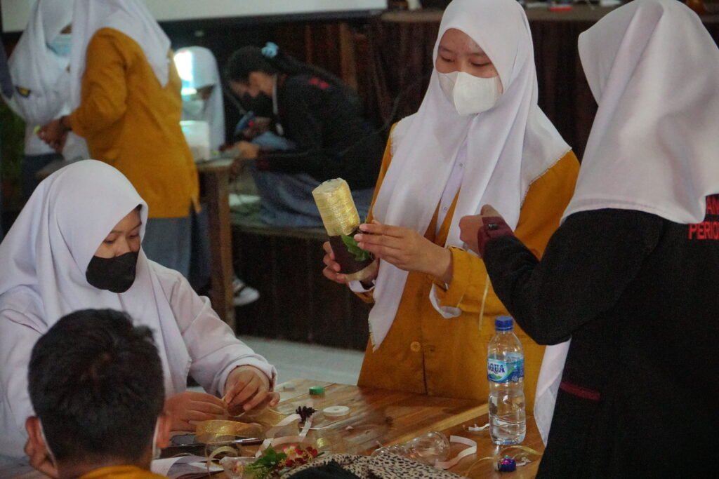 Isra Yanti (kanan almamater kuning) saat praktik pengolahan sampah botol plastik di kegiatan Gerakan Zero Plastic Waste. Foto: Kendariinfo. (19/10/2021).