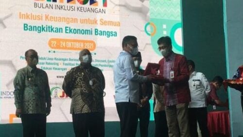 Penyerahan penghargaan kepada kepala daerah yang aktif mengedukasi masyarakat tentang inklusi keuangan.