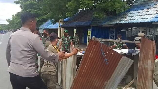 Puluhan personel dari kepolisian, TNI, dan Satpol PP membersihkan sisa sampah dan merapikan jualan warga di Kendari Beach.