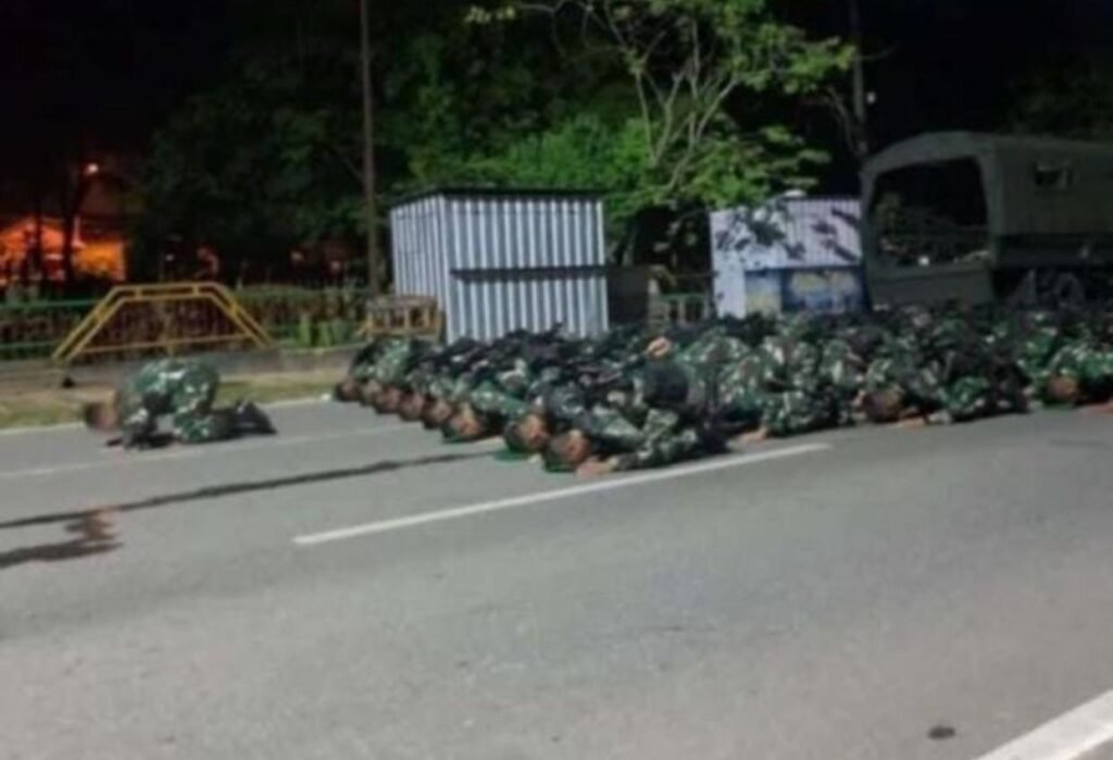 Personel TNI salat berjemaah di lokasi kericuhan di Kendari Beach.