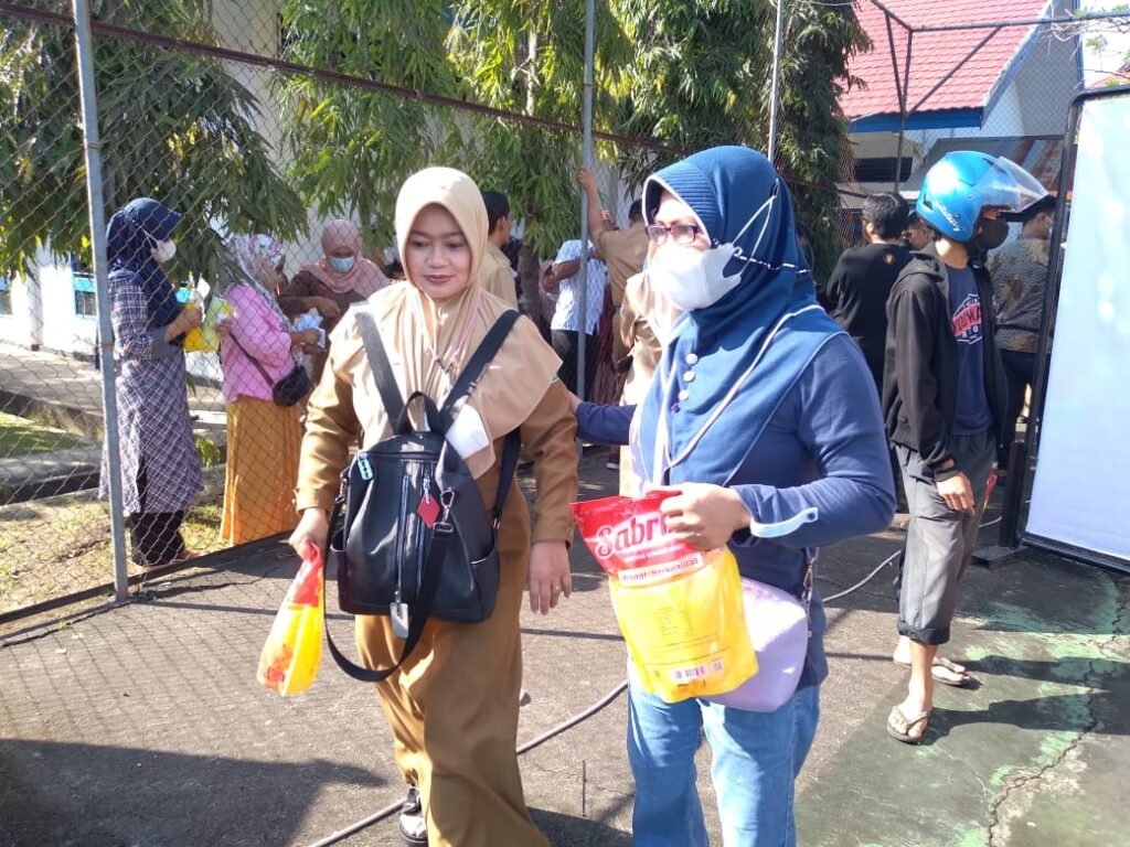 Ibu-ibu yang telah mendapatkan minyak goreng.