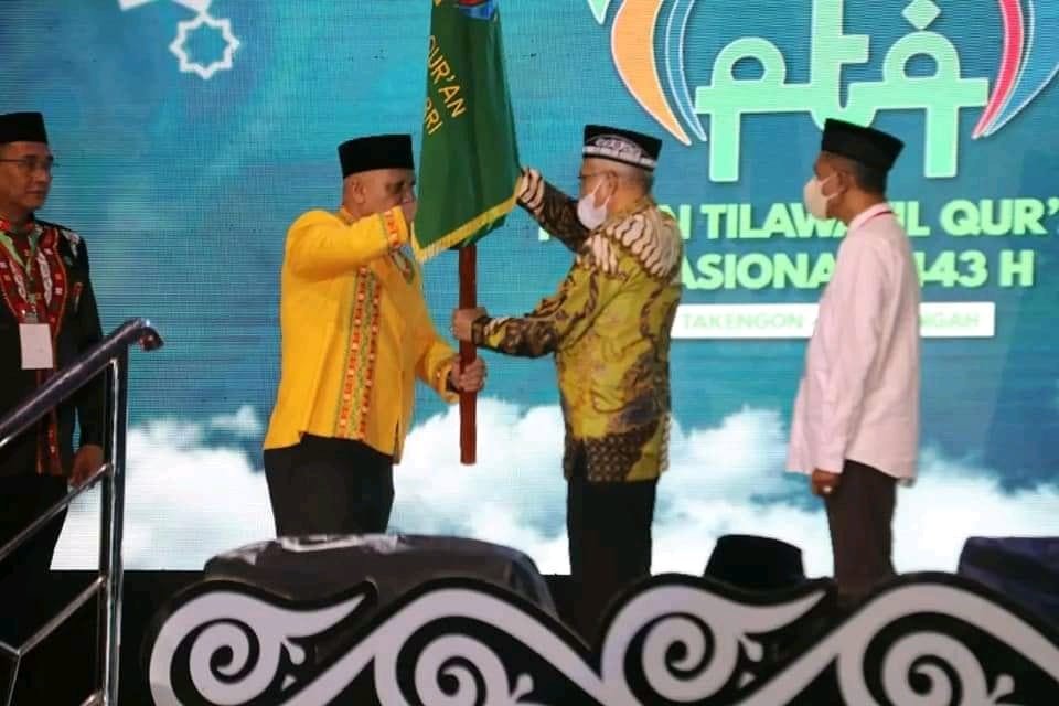 Bupati Aceh Tengah, Shabela Abubakar saat menyerahkan bendera pataka PTQ RRI ke Plh Sekda Sultra, Asrun Lio.