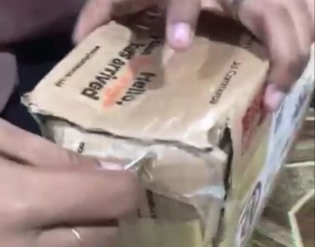 Vivin saat membuka dos usai memesan HP via online. 