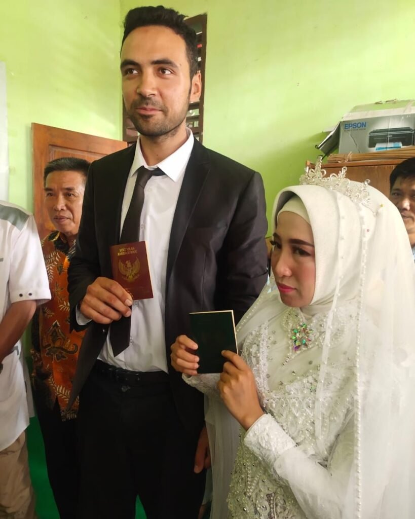 Tugay Errol asal Turki dan Risnawati asal Konawe Selatan saat memperlihatkan buku nikah di KUA Kendari.
