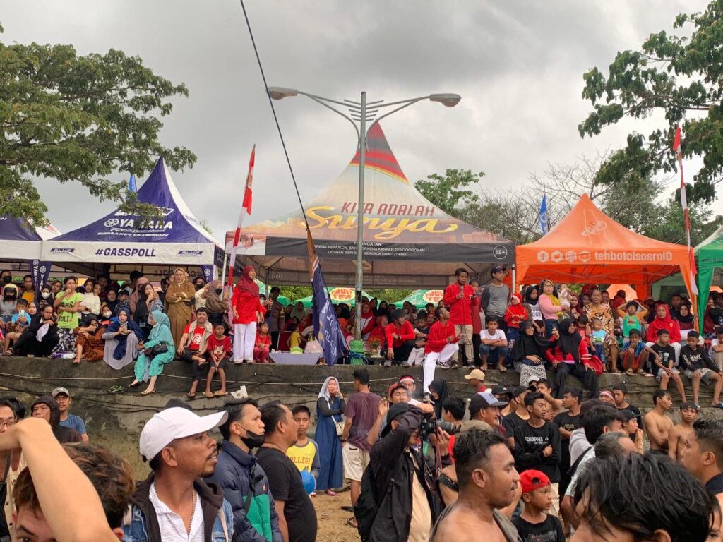 Penonton panjat pinang di Kendari Beach, Kelurahan Punggaloba, Kecamatan Kendari Barat.