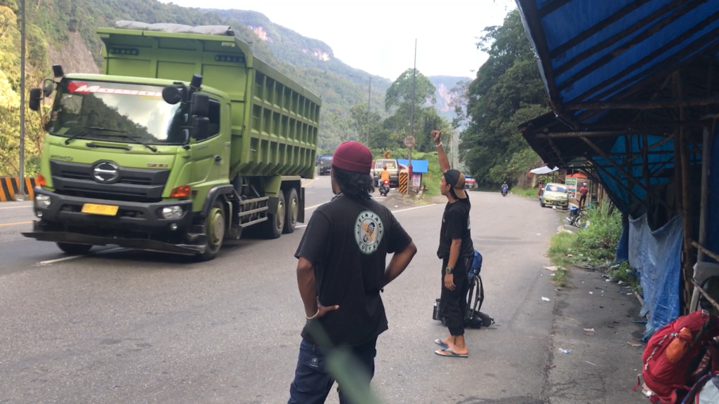 Arisandy dan Ardianto menunggu tumpangan kendaraan yang akan membawa mereka ke tempat tujuan.