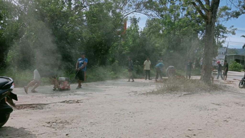Warga menambal jalan rusak di kawasan Nangananga, Jalan Haluoleo, Kelurahan Mokoau, Kecamatan Kambu, Kota Kendari.
