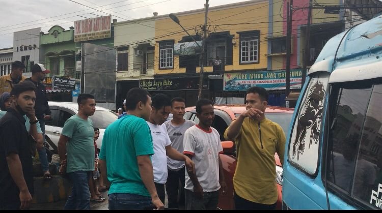 Pengemudi mobil (baju kuning) yang mengamuk karena jalannya menuju rumahnya di blokir di pertigaan Kampus UHO Kendari.