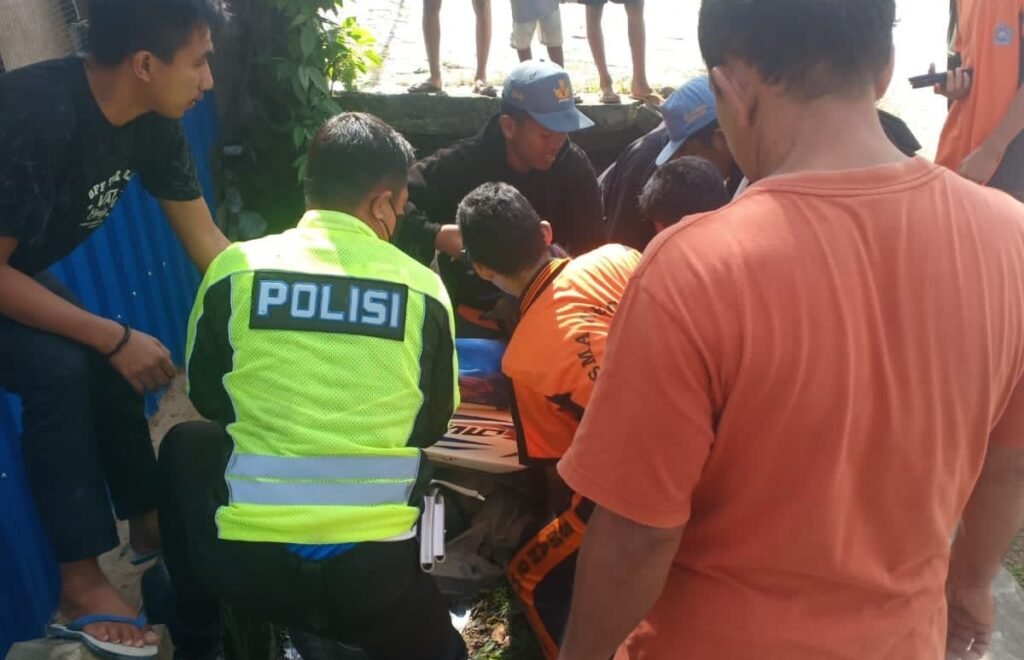 Warga dan aparat kepolisian mengevakuasi  motor yang terlibat laka lantas tunggal.