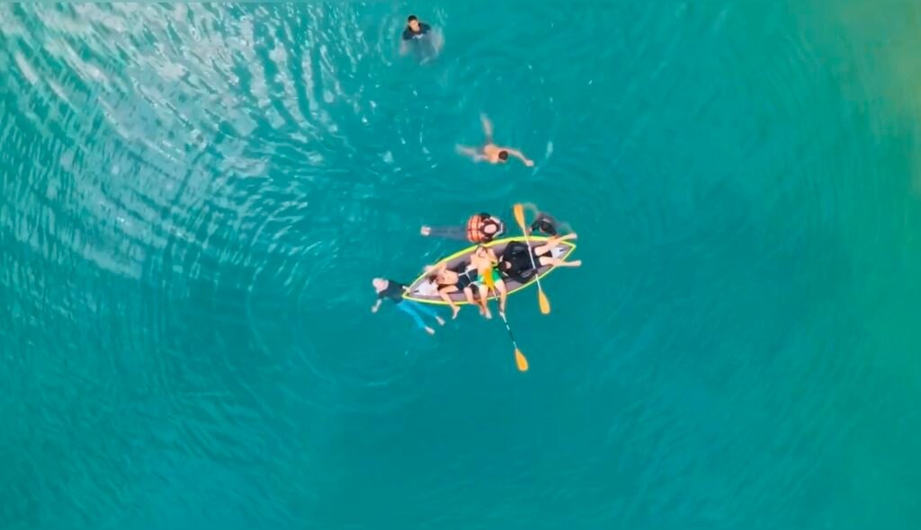 Wisatawan berenang menggunakan kano untuk menikmati keindahan Telaga Biru Oheo Konut.