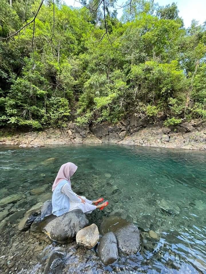 Wisatawan menikmati keindahan Kali Biru di tengah hutan Wawonii Tenggara.