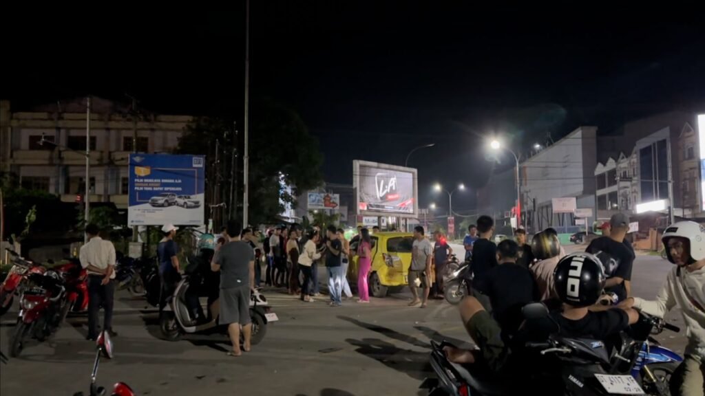 Suasana warga yang melintas di Perempatan Pasar Baru Kendari melihat kondisi mobil Daihatsu Ayla yang terlibat kecelakaan dengan mobil Toyota Rush.