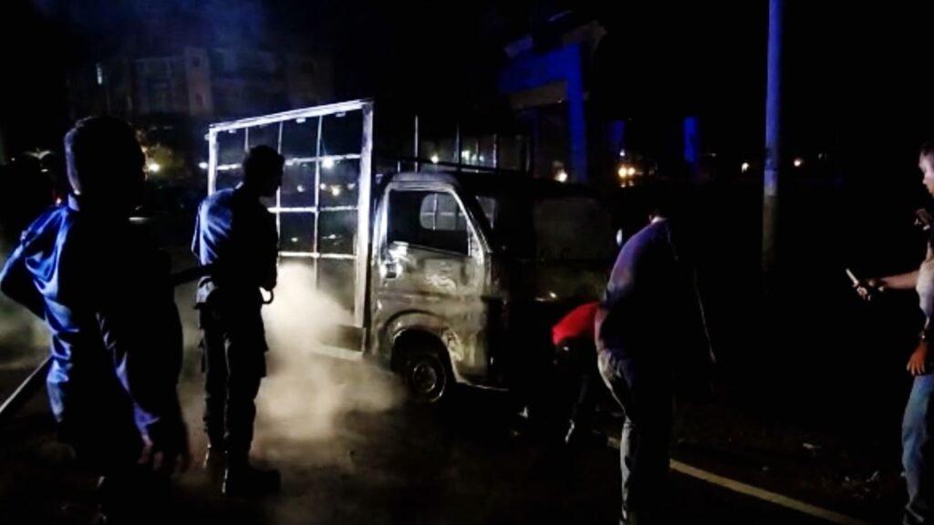 Petugas Damkar Kendari saat memadamkan mobil yang terbakar.