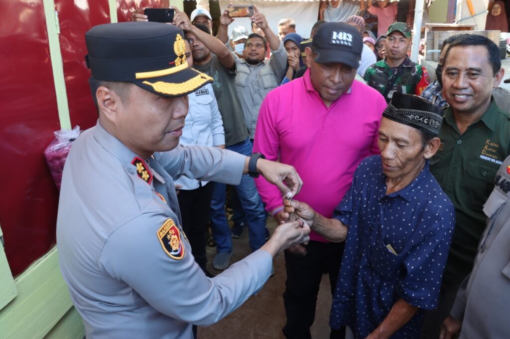 Warga bernama La Umpa saat menerima kunci rumah bantuan dari Polres Baubau.