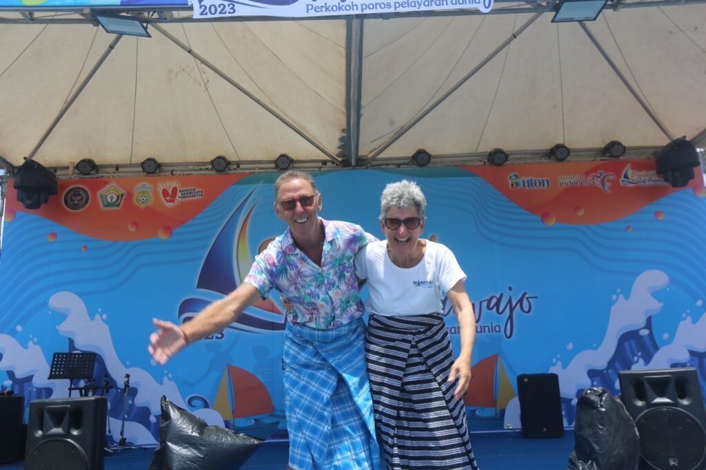 Potret dua wisatawan mancanegara di Festival Teluk Pasarawajo 2023 yang mengenakan tenunan khas Buton.