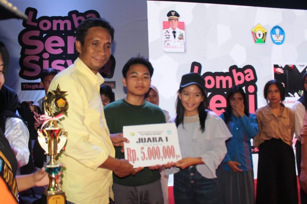 Kepala Dinas Dikbud Sultra, Yusmin saat memberikan hadiah kepada juara I lomba menyanyi solo.