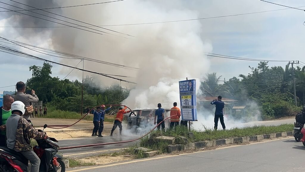 Pemadam kebakaran memadamkan mobil yang terbakar di Kendari.