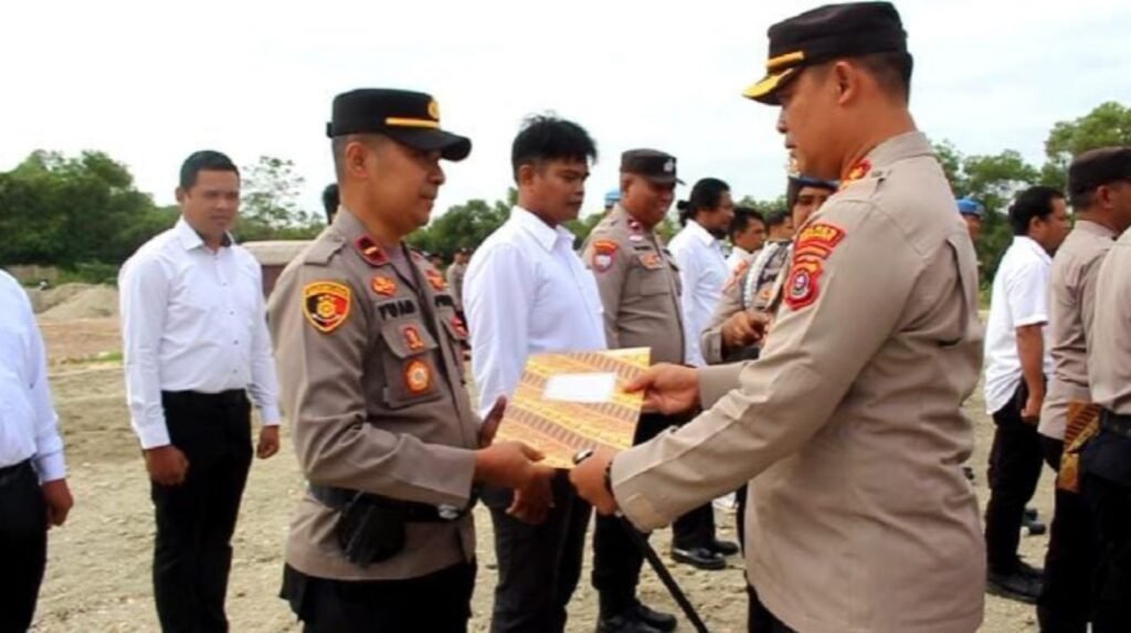 Kapolres Konawe, AKBP Ahmad Setiadi saat menyerahkan penghargaan kepada Kapolsek Bondoala, Ipda Fuad Hasan.