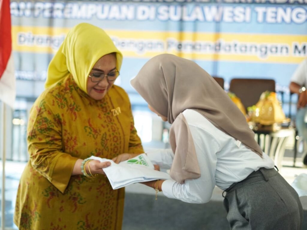 Calon Gubernur Sulawesi Tenggara (Sultra), Tina Nur Alam, menerima baju dari pengurus Nura Daya Pemerhati Rentan (NDPR) usai penandatanganan memorandum of understanding (MoU) di Kota Kendari.