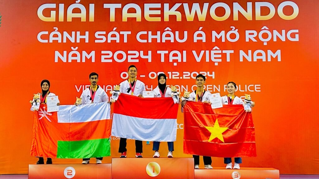 Bripda Risky Irma Suryani mengibarkan bendera Merah Putih usai meraih medali emas pada ajang Asian Open Police Taekwondo Championship 2024 di Vietnam.