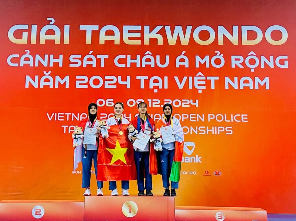 Bripda Risky Irma Suryani mengibarkan bendera Merah Putih usai meraih medali emas pada ajang Asian Open Police Taekwondo Championship 2024 di Vietnam.