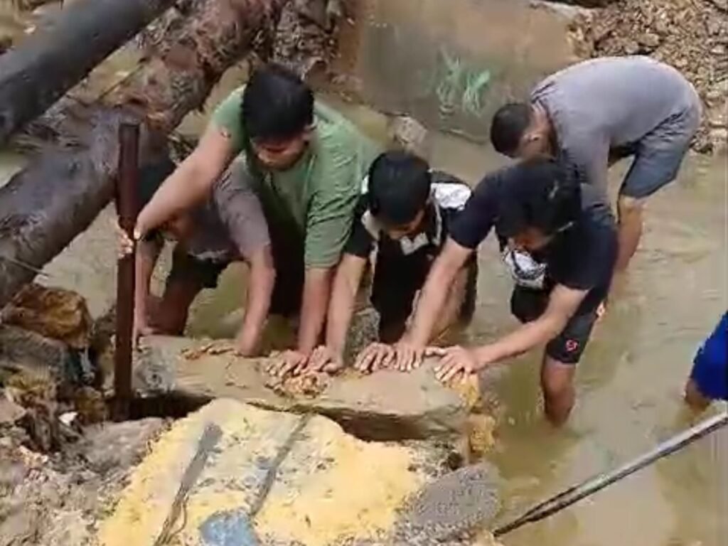 Warga bergotong royong membuat jembatan dari pohon kelapa di Jalan Banda, Kelurahan Watulondo, Kecamatan Puuwaatu, Kota Kendari.