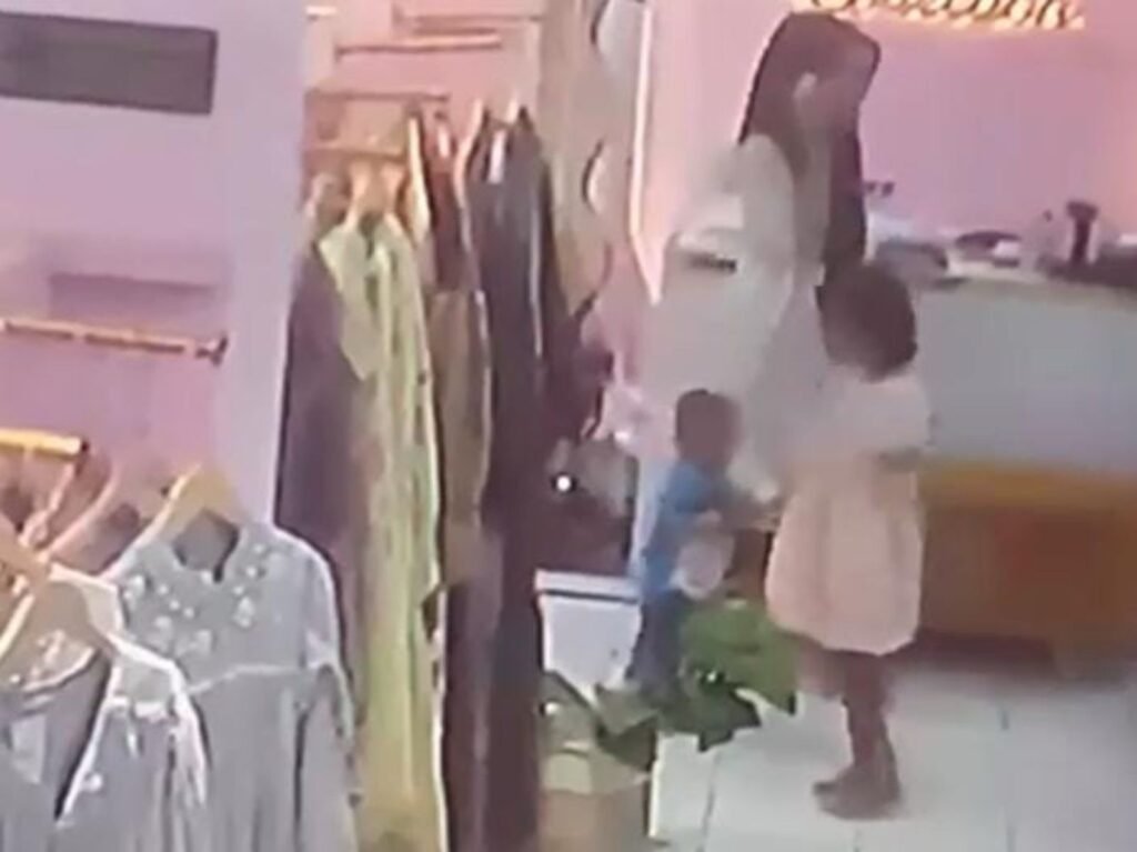 Pelaku pencurian handphone milik penjaga kasir toko pakaian bersama dua anaknya saat berkeliling di dalam area toko.