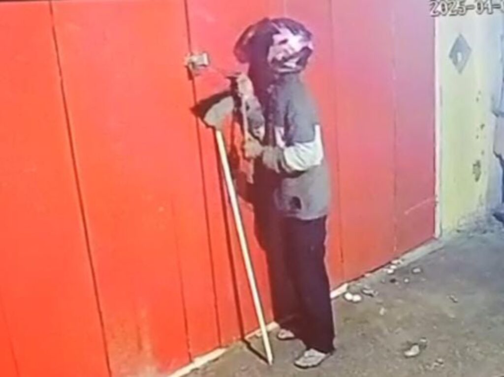 Salah satu pelaku yang sedang berupaya merusak gembok pintu konter HP. Foto: Istimewa/Tangkapan Layar CCTV.