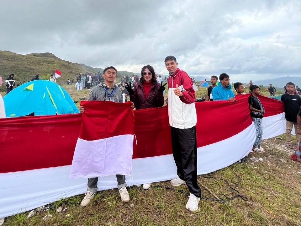Warga saat membentangkan bendera Merah Putih sepanjang 80 meter di puncak Bukit Lamando, Desa Sandang Pangan, Kecamatan Sampolawa, Kabupaten Buton Selatan (Busel).