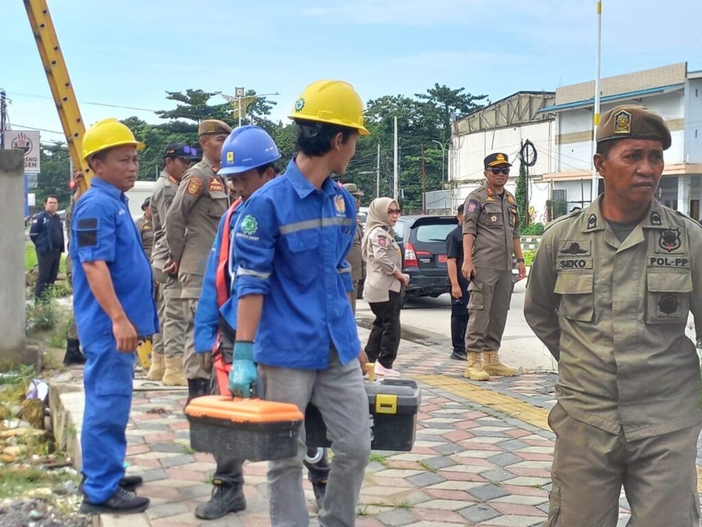 Proses pemutusan aliran listrik oleh Pemkot Kendari terhadap salah satu bangunan yang dinilai melanggar ketentuan sempadan jalan.