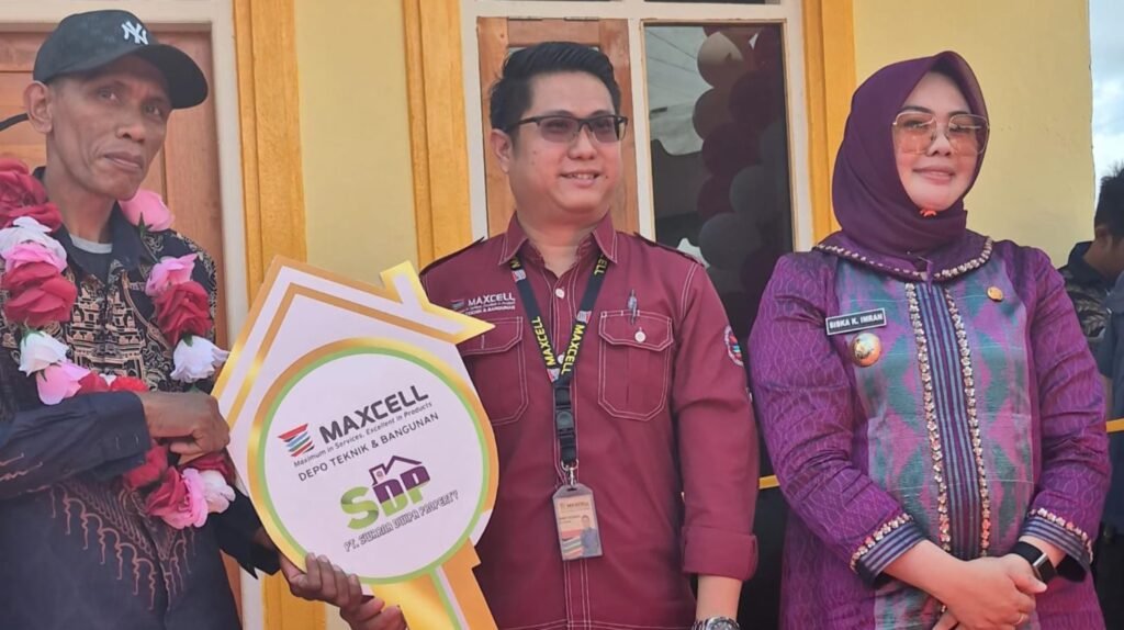 General Manager Operational Maxcell Depo Teknik dan Bangunan, Randy Natanael, didampingi Wali Kota Kendari, Siska Karina Imran, saat menyerahkan kunci rumah pemenang undian.