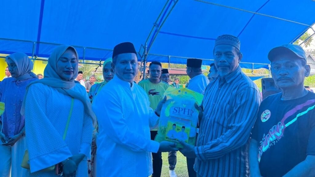 Bupati Muna Barat dan Ketua DPD Golkar Sultra, La Ode Darwin menyerahkan paket beras kepada salah seorang warga Tongkuno Raya, Kabupaten Muna.