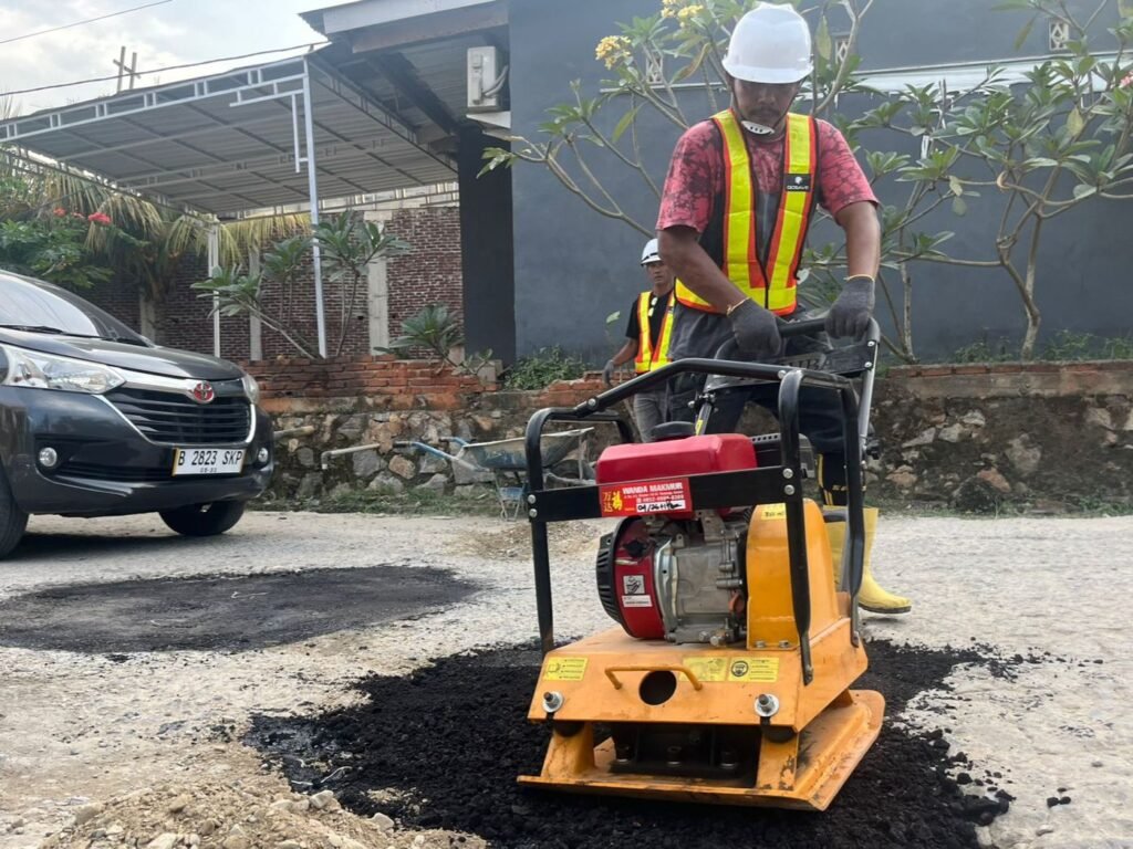 Tim Abulangit Official saat meratakan aspal dingin di sebuah lubang di Jalan Terong, Kelurahan Mokoau, Kecamatan Kambu, Kota Kendari.