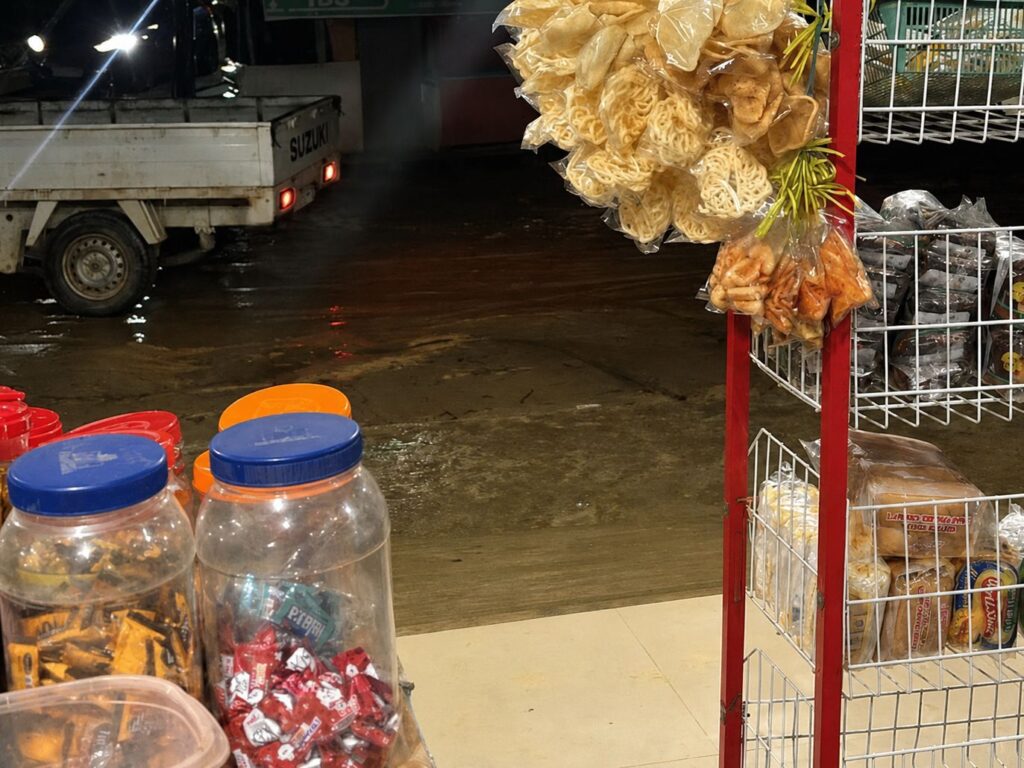 Kondisi di depan warung warga Jalan Tunggala, Kelurahan Anawai, Kecamatan Wuawua, berlumpur setelah hujan deras mengguyur.