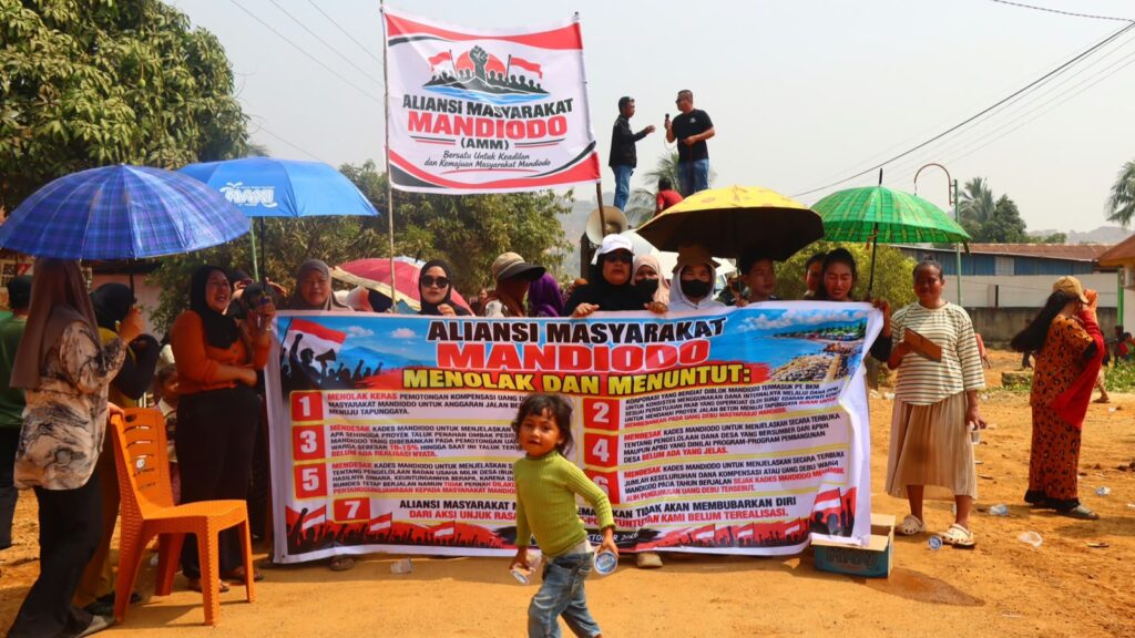 Warga yang tergabung dalam Aliansi Masyarakat Mandiodo (AMM) membawa spanduk berisi tujuh poin tuntutan saat menggelar aksi unjuk rasa di Desa Mandiodo, Kecamatan Molawe, Kabupaten Konawe Utara (Konut).