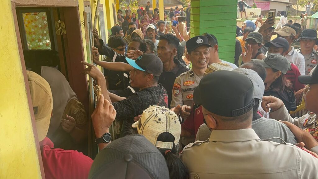 Aparat kepolisian dan warga bersitegang saat proses penyegelan Kantor Desa Mandiodo, Kecamatan Molawe, Kabupaten Konawe Utara (Konut).